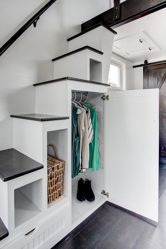 Rangement sous les escaliers dans une mini-maison sur pieux vissés.