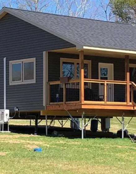 Blue home with veranda on screw pile by Postech North Central BC